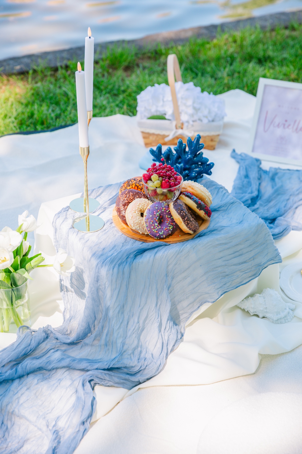 Coastal-themed picnic spread with donuts, fruit and blue coral accents