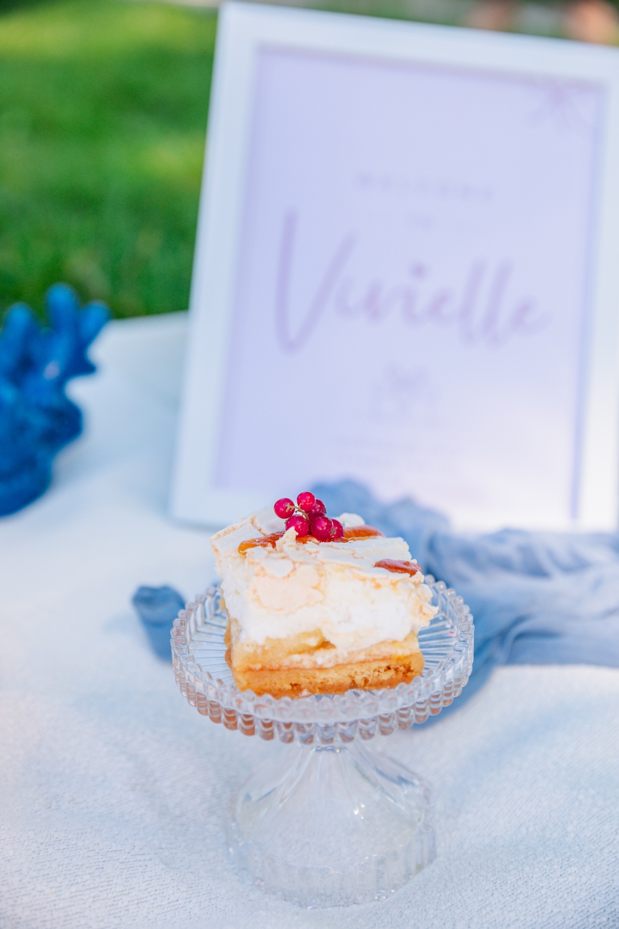 Layered dessert with red currants on a crystal cake stand