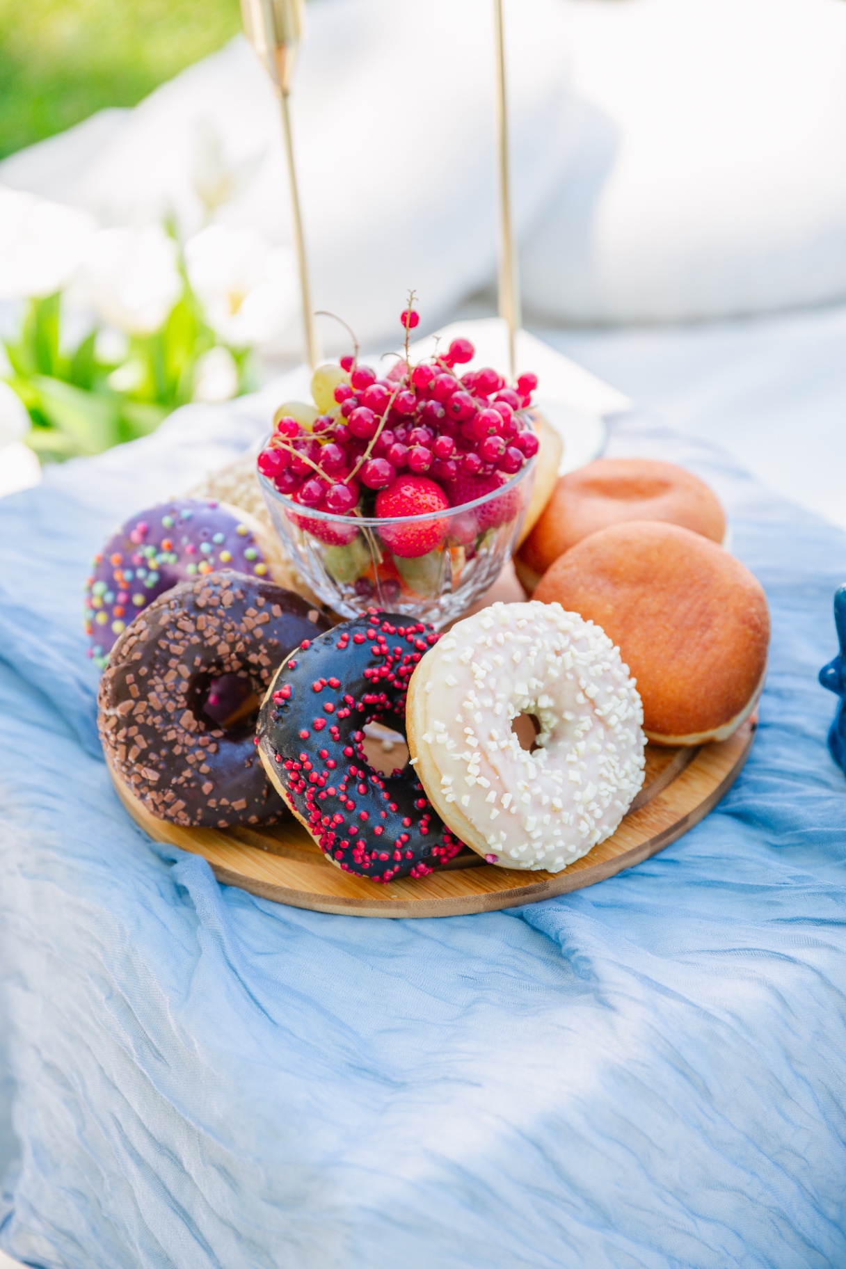 Pastel donut platter with berries on a blue gauze tablescape
