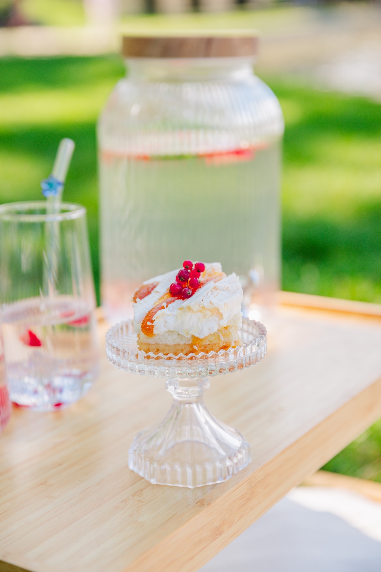 Lemon dessert slice on a crystal stand with infused water dispenser